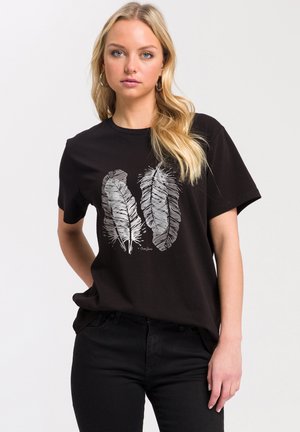 Czarny bawełniany t-shirt z dwoma białymi nadrukami piór. Krótkie rękawy, okrągły dekolt, luźny krój. Noszony z czarnymi dżinsami.
