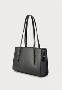 Sac fourre-tout en similicuir noir avec deux longues poignées, design minimaliste, fermeture éclair et détails en métal doré.