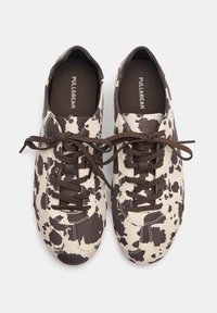 Sneaker mit einem braun-weißen Kuhfellmuster, aus Baumwollmaterial, mit runder Spitze und braunen Schnürsenkeln. Minimalistische Markenkennzeichnung auf der Innensohle.