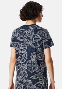 Marineblauw katoenen T-shirt met een wit cirkelpatroon met sterren. Korte mouwen en een ronde halslijn. Zachte, gladde textuur.