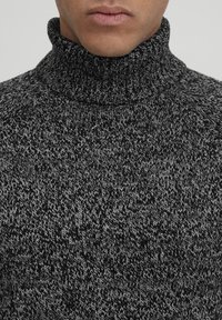 Dunkelgrauer Rollkragenpullover mit strukturiertem Strickmuster, ausgestattet mit hohem Kragen und kontrastierenden helleren Fäden.