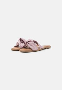 Lilla stoff slidesandaler har et knyttet stroppdesign, flat lysebrun såle og en glatt tekstur. Lett og åpen tå.