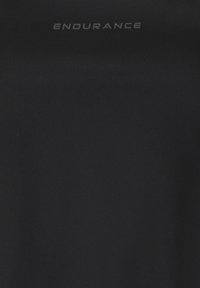 Sort tekstureret stof med ordet "ENDURANCE" trykt med store bogstaver tæt på øverste midte.