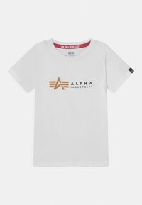 Bijela pamučna majica s zlatnim i mornarsko plavim logotipom kutnog dizajna. Ovratnik je okrugli, a u izrezu se nalazi crveni detalj.