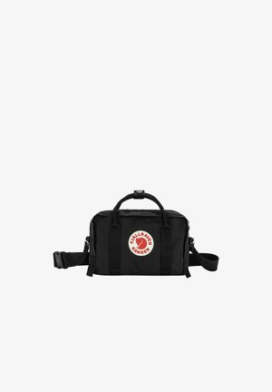 Petit sac noir Fjällräven Kånken avec poignées supérieures, bandoulière réglable et écusson logo rouge et blanc à l'avant.