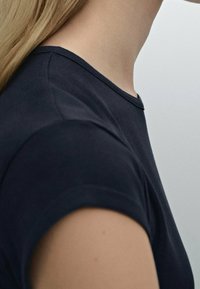 Svart crew neck t-shirt med korta ärmar, slät tyg, figurnära design, minimala sömnadsdetaljer, inga synliga mönster eller accenter.