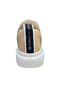 Beige sneakers met een gestructureerde afwerking, voorzien van een nepbont kraag, zwart-witte gestreepte hielaccenten en geperst merk op de zool.