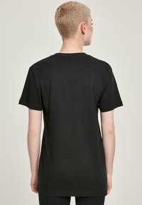 Sort bomulds t-shirt med rund hals, korte ærmer og en afslappet pasform, med enkle syningsdetaljer og en glat tekstur.