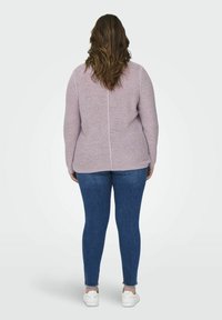 Lillakast kootud särk, millel on tekstuuriga viimistlus, pikal varrukal ja keskkohtõmblus, kombineeritud siniste kitsaste teksade ja valgete tossudega.