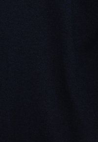 Mörk marinblå stickad tyg med fin, jämn textur och subtila skuggor som indikerar mjuka veck.