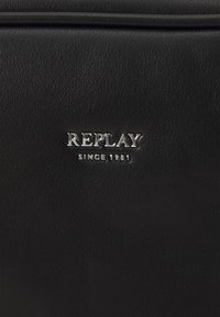 Borsa in pelle nera con superficie testurizzata. Presenta un logo argento "REPLAY" e l'iscrizione "SINCE 1981" nella parte inferiore.