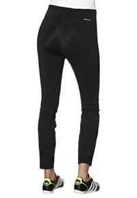 Czarne spodnie sportowe o dopasowanym kroju, z paskiem w talii i boczną kieszenią. Materiał o fakturze zapewniającej elastyczność i swobodę ruchów.
