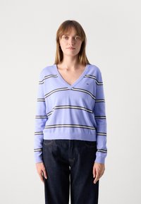 Pull rayé violet avec col en V, manches longues et rayures contrastées gris foncé et blanches, fabriqué en matière tricot douce.
