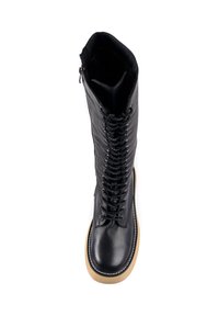 Stivale nero in pelle fino al ginocchio con lacci anteriori e zip laterale. Presenta una suola in gomma beige e dettagli cuciti lungo il bordo.