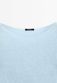 Pull en maille bleu clair avec un col rond et une étiquette noire indiquant "Massimo Dutti Made in China" au niveau du col arrière.