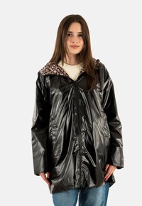 Impermable negro brillante con collar de estampado de leopardo, cremallera frontal y bolsillos laterales; cuenta con un corte holgado y una textura brillante.
