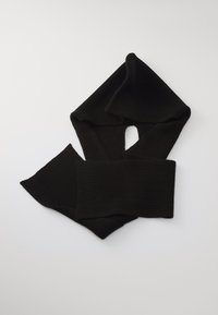 Cachecol de malha canelada preto dobrado sobre uma superfície branca, com uma extremidade enfiada através de um laço no meio.