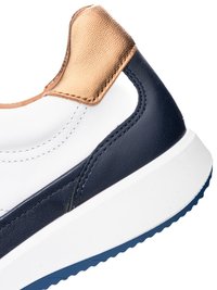 Close-up of sneaker heel featuring white, navy blue, and tan leather panels with detailed stitching and a thick white sole.