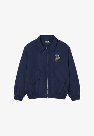 Donkerblauw jack met rits en kraag, twee voorzakken met klep, elastische manchetten en zoom, en een klein geborduurd groen krokodillenlogo met geel ontwerp op de borst.