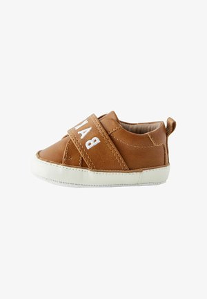 Braunes Leder-Baby-Schuh mit einer weißen Gummisohle, ausgestattet mit einem Klettverschluss über der Vorderseite und einem kleinen Ziehschlaufe an der Rückseite.
