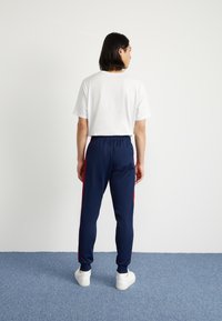 adidas Originals SST TP - Treniņtērpa apakšdaļas - night indigo/better scarlet