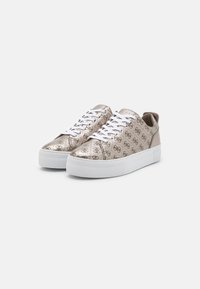 Sneakers color oro metallico con tomaia a motivo, lacci bianchi e una suola spessa bianca. Il design presenta loghi in rilievo e una finitura liscia.