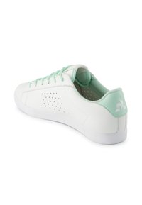 Sneaker in pelle bianca con dettagli verde menta, perforazioni testurizzate sui lati e suola liscia. Presenta lacci e logo sul tallone abbinati.