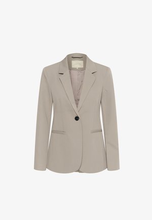 Ljusbeige blazer gjord av slät tyg med notch-krage, en svart knapp och två framfickor. Fodrad med ett mjukare beige material.