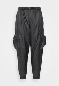 Black cargo pants made of shiny synthetic material. Features an elastic waistband, tapered cuffs, and multiple zippered pockets.