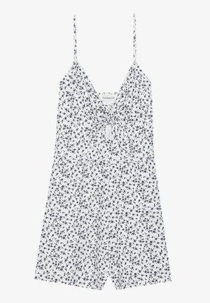 Floral romper in white and navy, made of lightweight fabric. Features a deep V-neck, adjustable straps, and a tied front detail.
