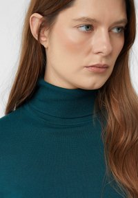 Turkusowy sweter z golfem o prążkowanej strukturze, dopasowanym kroju i wysokim kołnierzu. Gładki materiał, minimalna widoczność szwów.