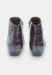 Burgundy ankle boots with a glossy crocodile-textured finish, side zippers, and a low heel for added support and stability.