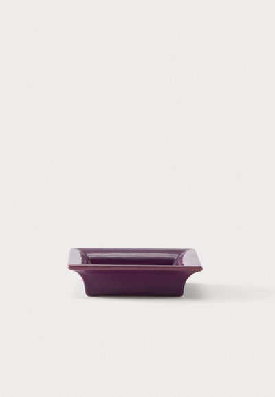 Plat carré en céramique violet profond avec des bords légèrement évasés sur fond blanc.