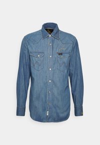 Camicia di jeans blu a maniche lunghe con tasche sul petto a bottoni, bottoni a pressione sul davanti e cuciture a contrasto sulle tasche e sul colletto.