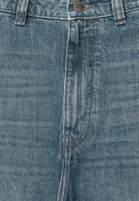 Jeans in denim azzurro chiaro con una texture sbiadita, dotati di chiusura con bottone, design tradizionale a cinque tasche e cuciture a contrasto.