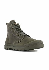 Bottine en cuir vert à bout rond, avec une semelle en caoutchouc, des lacets gris, des œillets dorés et un patch logo sur le côté.