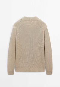 Pull beige en tricot à manches longues, avec des poignets côtelés et un col replié, vu de dos sur un fond blanc.