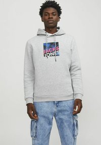 Sudadera de algodón gris con cordones, que presenta un logo gráfico que dice "JACK & JONES" en rosa y azul sobre un cuadrado negro.