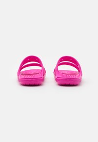 Infradito rosa in gomma con un sottopiede testurizzato, due ampi cinturini per un migliore supporto e una suola piatta. Design semplice con una finitura liscia.