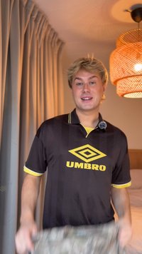 Black short-sleeve jersey with yellow accents and "UMBRO" logo on the chest. Features a patterned texture and classic collar design.