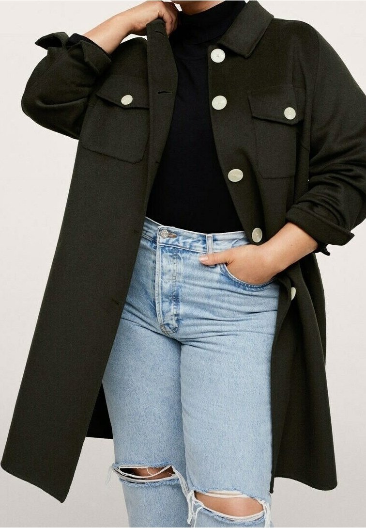 Chaqueta de gran tamaño en color verde olivo con botones grandes y dos bolsillos en el pecho, combinada con jeans rotos de color azul claro. El tejido parece texturizado.