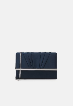 Pochette bleu marine avec un design plissé, un détail métallique horizontal argenté et une bandoulière chaîne argentée sur un fond gris clair uni.