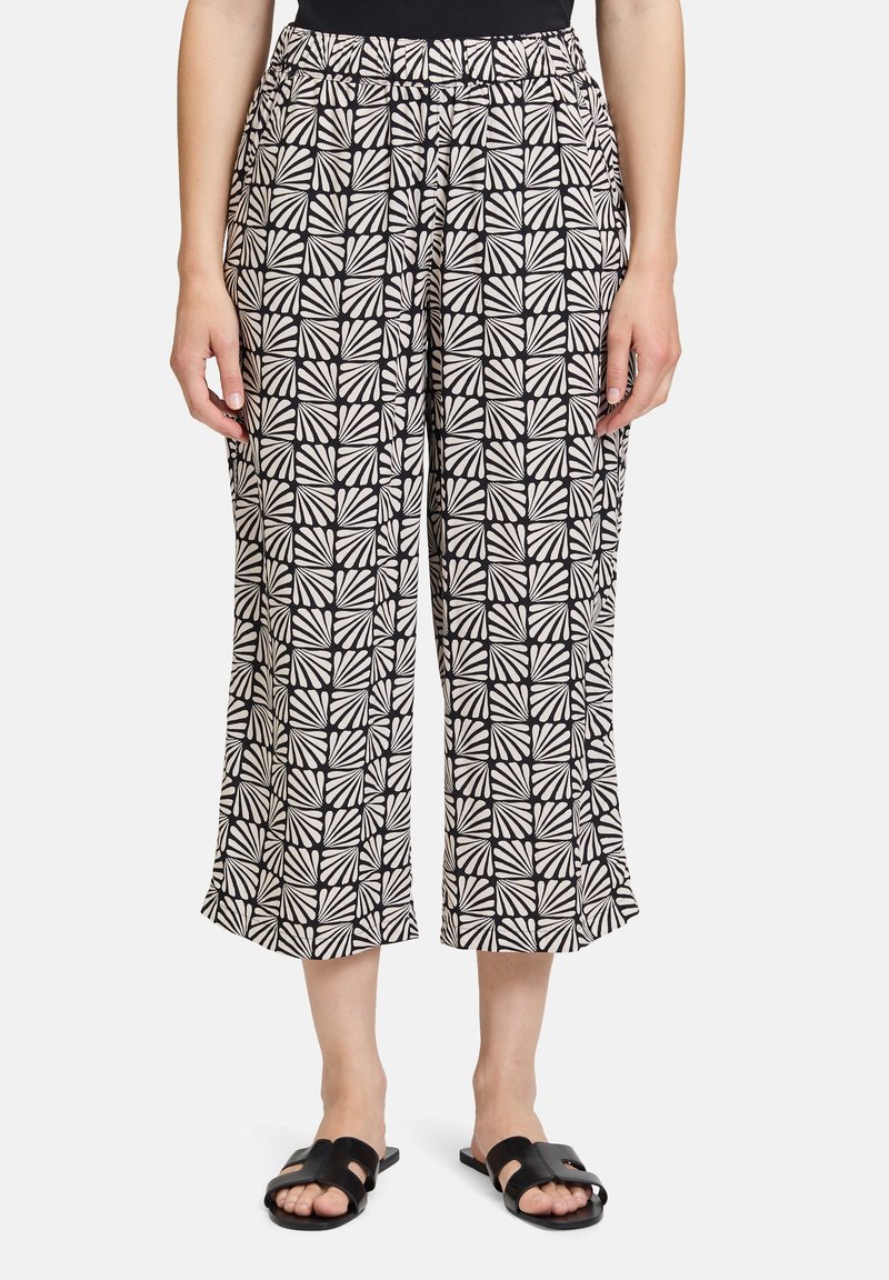Czarno-białe spodnie o szerokich nogawkach z geometrycznym wzorem, z elastycznym paskiem w talii i krótką długością.