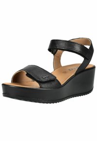 Černá kožená klínová sandála s kotníkovým páskem a nastavitelným předním páskem, světle hnědou stélkou a strukturovanou podrážkou pro lepší přilnavost.