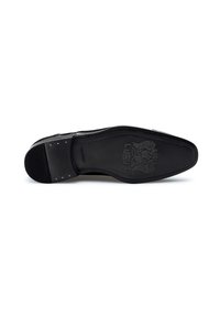 Semelle de chaussures en cuir noir avec une finition texturée, présentant une empreinte de logo et un design élégant. Des éléments en acier inoxydable sont visibles près du talon.