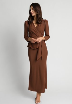 Brązowa sukienka rozkloszowana z długimi rękawami i peplum w talii. Wykonana z gładkiego materiału, ma głęboki dekolt w kształcie litery V i wiązanie w talii.