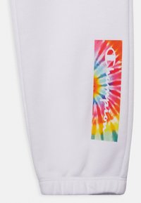 Sweatshirt branco com um patch de logotipo em padrão tie-dye colorido apresentando a palavra "Champion". A textura do tecido parece suave e ligeiramente texturizada.