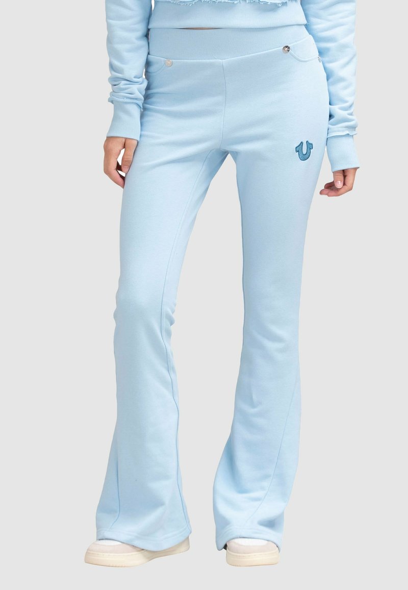 Pantalons de jogging évasés bleus en tissu doux, avec un motif cousu, un logo discret et une taille ajustée avec des poches.