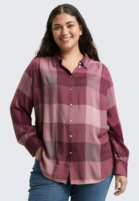 Langarmshirt in tinten van bordeauxrood en roze met een geruit patroon, voorzien van een knoopsluiting aan de voorkant en een ontspannen pasvorm.