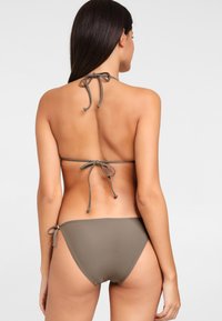 Bikini-set in olijfgroen, met een halternek met strik achter en zij-touwen aan de onderkant, gemaakt van gladde stof met een minimalistisch ontwerp.